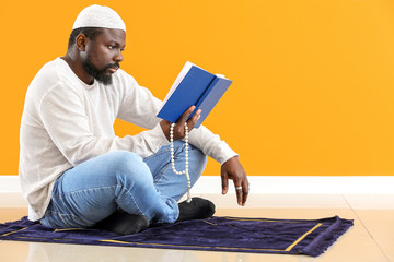 Wall Mural - African-American Muslim man praying indoors