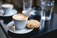 Cup Of Coffee And Cookie On A Table