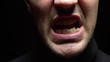 Leinwandbild Motiv closeup. male mouth with crooked teeth screaming. Black background.