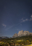 Fototapeta Kosmos - Starry night with mountain peak and town ​​Cortina d'Ampezzo in Dolomites, South Tyrol, Italy