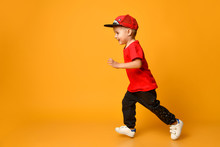 Smiling Little Boy Running Left Over Yellow Background