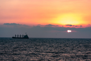 Freight ship silhouette on a sunset horizon