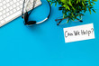 © 9dreamstudio - Customer support service concept. Text Can We Help near headset on blue office desk top-down copy space