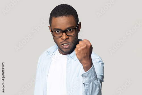 Fotomural Angry annoyed african american millennial man showing clenched fist