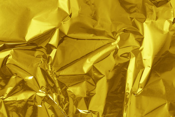 Gold foil leaf shiny texture, abstract yellow wrapping paper for background and design art work.