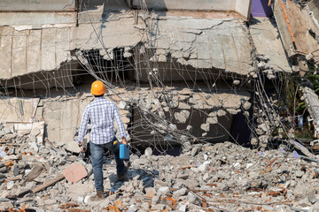 Wall Mural - Engineer or contractor holding tool box in destruction demolishing building.