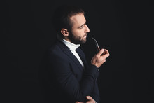 Portrait Of Stylish Young Man With Smoking Pipe On Dark Background