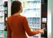 © zigres - Young traveler woman choosing a snack or drink at vending machine in airport. Vending machine with girl.