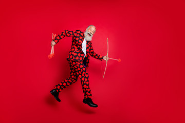 Sticker - Full length profile photo of funky crazy aged guy cupid jumping up high hobby make feelings aiming couples love arrows wear hearts pattern suit isolated vivid red color background