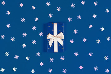 Wall Mural - Gift box with surprise on classic blue background. Flat lay, top view.