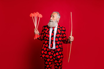 Sticker - Portrait of his he nice attractive serious trendy white-haired guy wearing heart pattern cherub holding in hands arrows wedding isolated on bright vivid shine vibrant red color background