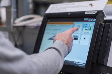 Man paying at the self-service counter using the touchscreen display and credit card. Isometric self-service cashier or terminal.