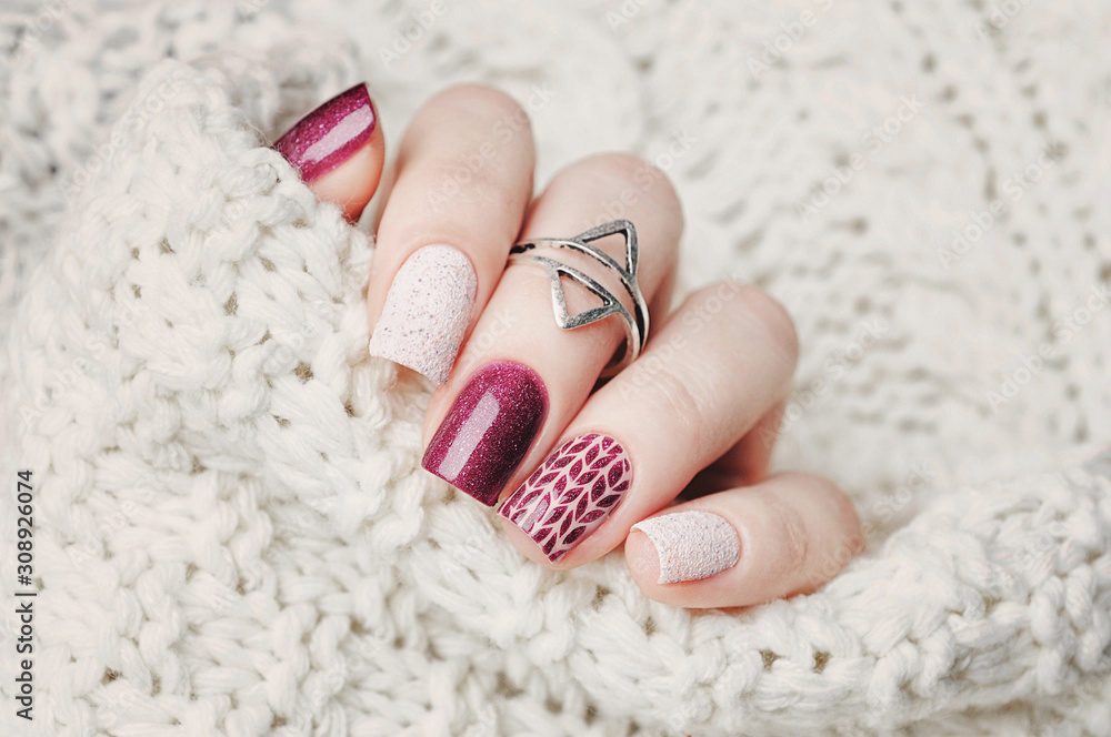 Fotografia winter nail art manicure and knitted sweater on the background