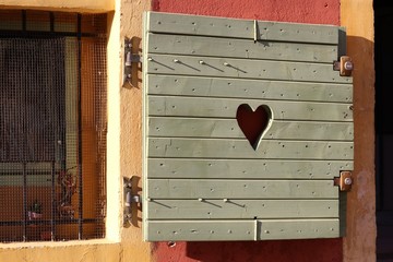 Wooden shutters on windows. Love and peace concept. Heart sign