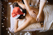 Leinwandbild Motiv Masseuse massaging girl with Christmas lights in background