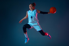 Target. Young Caucasian Female Basketball Player On Blue Studio Background In Neon Light, Motion And Action. Concept Of Sport, Movement, Energy And Dynamic, Healthy Lifestyle. Training, Practicing.