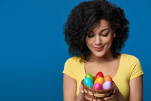 Smiling Woman Holding A Basket With Colorful Easter Eggs