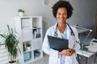 © lordn - Portrait of female African American doctor standing in her office at clinic