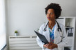 © lordn - Portrait of female African American doctor standing in her office at clinic