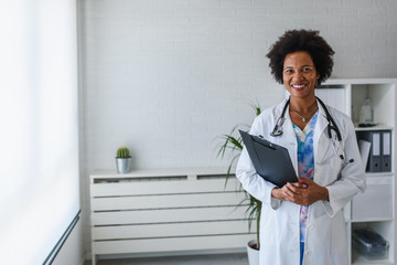 Portrait of female African American doctor standing in her office at clinic