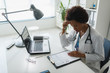 © lordn - Serious concentrated African American doctor working in her office at clinic