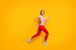 © deagreez - Full body profile photo of funky lady jumping high rushing discount shopping store addicted person wear casual striped t-shirt red trousers isolated yellow color background