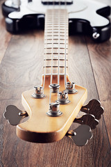 Wall Mural - Vintage electric bass guitar on wooden table background