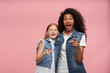 © timtimphoto - Surprised cheerful young ladies in casual clothes looking at camera with wide eyes and mouth opened, pointing ahead with raised index finger while posing over pink background