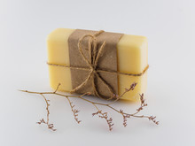 Yellow Handmade Soap And A Sprig Of Dried Flowers On A White Background