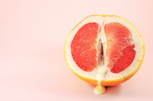 Sexy Grapefruit With Sperm, Erotic Concept. Sectional Grapefruit Is A Symbol Of The Vagina And Clitoris. Half Grapefruit With Dripping White Liquid On A Pastel Background. Erotic Concept.