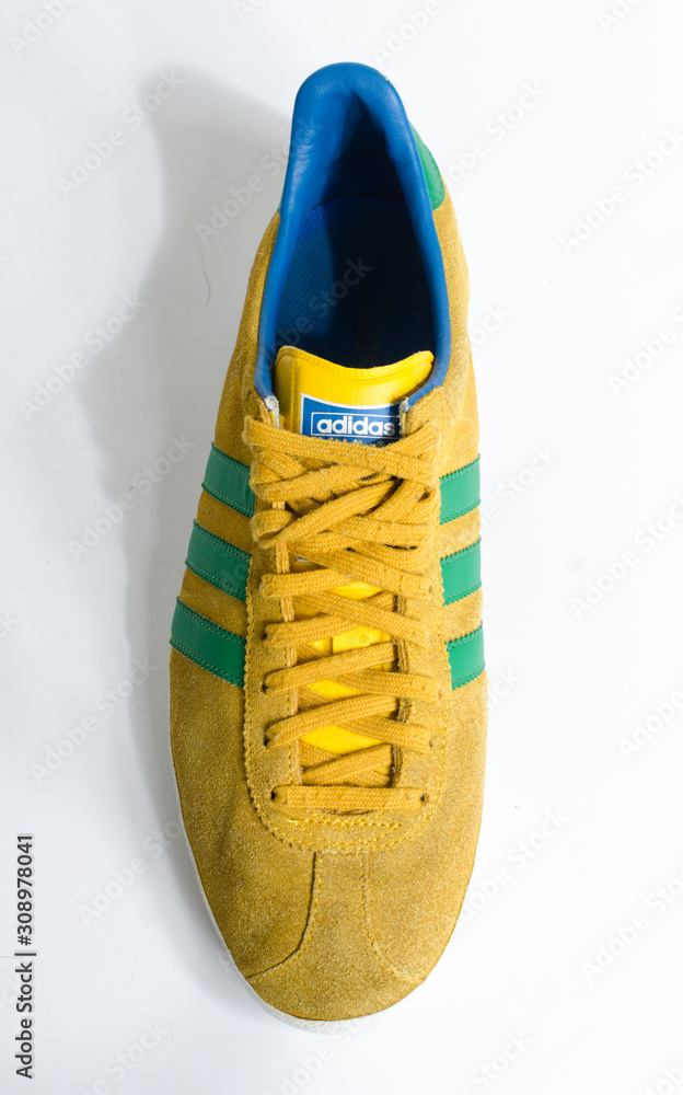 london, england, 05/05/2018 Adidas Gazelle Mustard Gold & Green Stripe  Trainers vintage sneaker trainers. yellow suede adidas trainers, stylish  retro football street fashion. famous three stripes Stock-foto | Adobe Stock