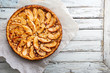 © petrrgoskov - Homemade delicious fresh baked rustic apple pie on white wooden background, top view