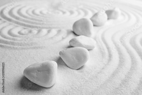 Dekoracja na wymiar  biale-kamienie-na-piasku-z-wzorem-zen-medytacja-harmonia