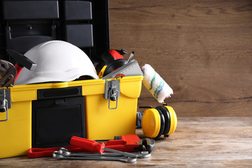 Plastic box with construction tools on wooden table. Space for text