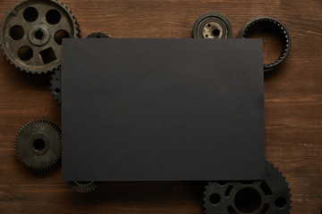 Sticker - top view of vintage black paper and gears on wooden table