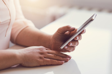 Wall Mural - woman sitting in office with mobile phone in hand