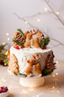 Homemade Christmas cake with gingerbread decorations on a grey background. New Year decor