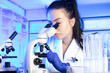 © zolnierek - Young scientist during experiment and using microscope in modern laboratory.