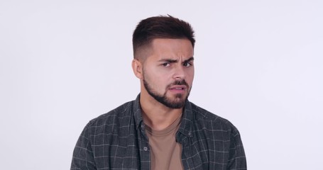 Canvas Print - Dissatisfied handsome young man on white background