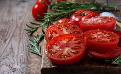 Sliced Tomato. Red tomatoes on a Wooden Cutting Board.