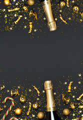 Wall Mural - Christmas and New Year background. Champagne bottle, golden christmas balls, festive ribbons, star confetti on black background top view. Flat lay holiday card. Party concept Festive decorations 2020