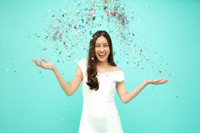 Cheerful Young Asian Woman Celebrating With Colorful Confetti Isolated On Green Background, Thai Model