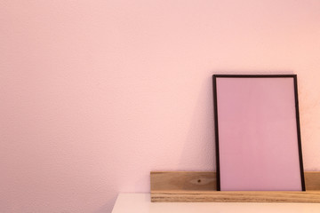 Wall Mural - Pink blank mock up of photo frame on the light background. Home interior, wooden shelf near pink wall