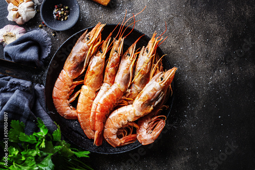 Cuadros en Lienzo Raw giant shrimps on dark table