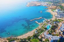 Cyprus Landscape. Aerial Panoramic View Of Bay With Sandy Beach And Hotel On Coastline, Drone Photo. Mediterranean Vacation And Travel Concept.