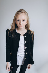 Close up portrait of little cute adorable girl posing alone on isolated white background in studio. Childhood, fashion kids, baby model concept