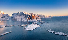 Amazing Aerial View Of Lofoten Islands Nature From Drone, Winter Sunrise Snowy Scenery Of Village Reine, Sakrisoy And Hamnoy During Beautiful Mountain Ridge With Alpenglow, Scene Over Polar Circle.