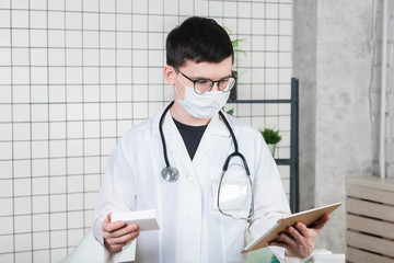 Man doctor surgeon works on a tablet computer in hospital