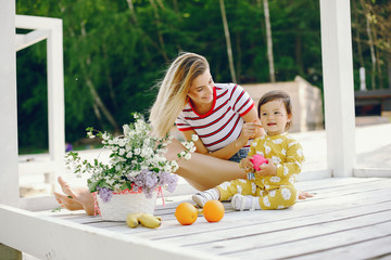 pretty mother with little daughter. family in a park. little girl in a yellow clothes