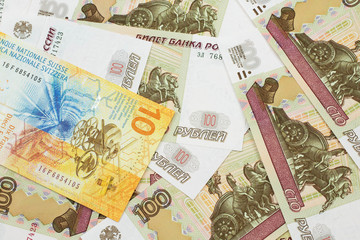 a yellow, ten swiss franc note from switzerland close up in macro with russian one hundred ruble bil